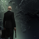 Agent 47 stares at a map while holding a silenced pistol in Hitman 3's new DLC.